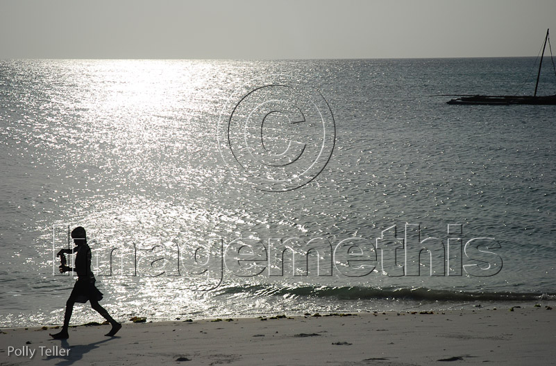 Manta Resort beach boy at sunset
